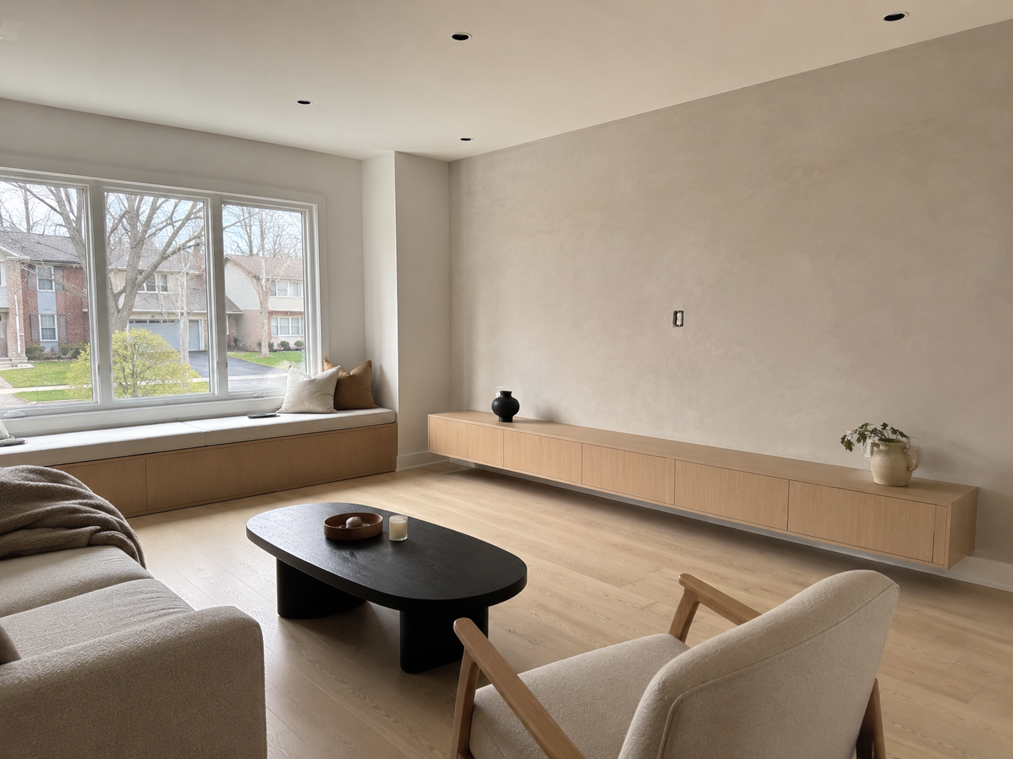 Minimalist living room with floating wood console and window bench